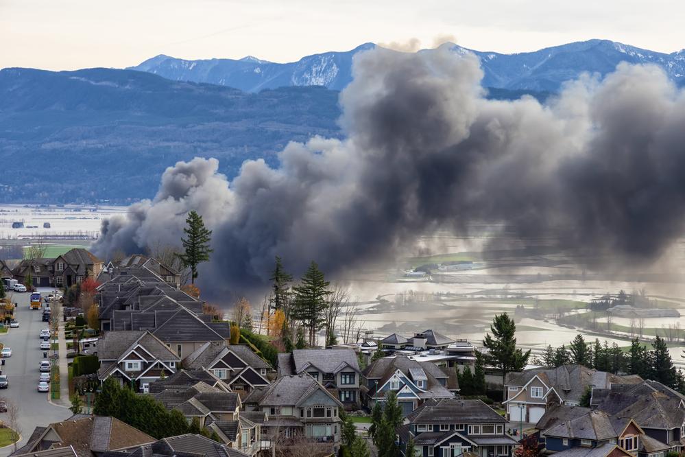 Devestating Flood and black smoke from fire in the city and farmland after storm.
